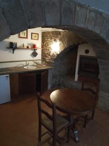 a kitchen with a table and a stone fireplace at La Guardiola in Bassano in Teverina