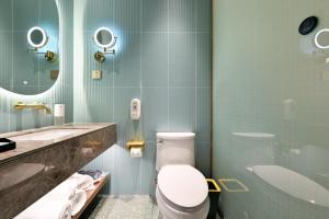 a bathroom with a toilet and a sink at Color and Light Hotel Beijing International Trade Shop in Beijing
