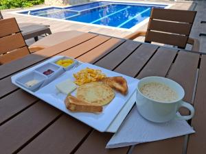a plate of breakfast food with a cup of coffee and toast at Akoya Meraki Casa Hotel in El Silencio