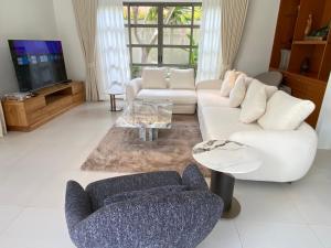 Una sala de estar con dos sofás y un televisor. en Residence Villa 3 Bedroom, en Bang Tao Beach