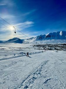 a group of people skiing down a snow covered slope at Hvanndalir Lodge in Ólafsfjörður