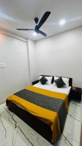 a bedroom with a bed with a ceiling fan at Sri Krishna Guest House in Nashik +2 photos