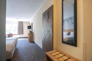 a hotel room with a bed and a mirror at Fletcher Hotel Restaurant De Eese in De Bult