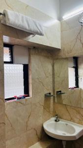 a bathroom with a sink and a window at Sri Krishna Guest House in Nashik