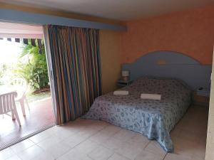 una camera da letto con un letto e una porta scorrevole in vetro di Sea view studio, beaches, pool bar, car option a Sainte-Anne