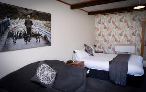 a hotel room with a bed and a couch and a painting at Glentanner Park Centre in Glentanner