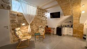a living room with a table and chairs and a kitchen at SFPH Caeser - AKKO in Acre