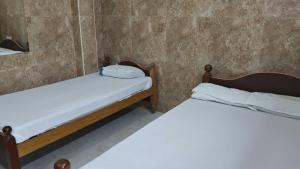 two twin beds in a room with a wall at Temple View Residency in Tiruvallūr
