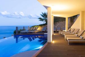 a swimming pool with lounge chairs and the ocean at Hotel Metropole Taormina in Taormina +69 photos