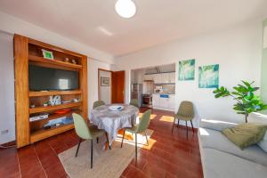 uma sala de estar com uma mesa, cadeiras e um sofá em Praia da Rocha Beach Step em Portimão