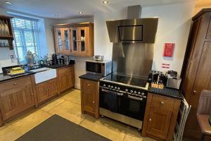 a kitchen with a stove top oven in a kitchen at Stunning 4 Bed Peak Dist Farmhouse Alton Towers in Waterfall