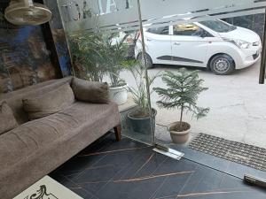 a living room with a couch and potted plants at Hotel Sr Residency Jail Road Tilak Nagar in New Delhi
