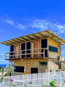 a house built on top of a white fence at Beach Cabin in Santa Marianita