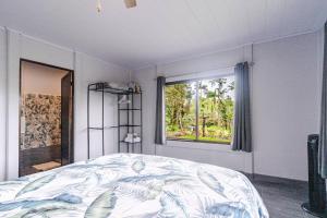 a bedroom with a bed and a window at Pura Vidaville - Toucans Nest in El pilon
