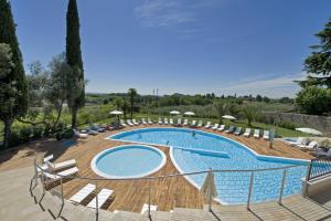 une grande piscine entourée de chaises longues. dans l'établissement Villa Luisa Resort & Luxury Apartments, à San Felice del Benaco