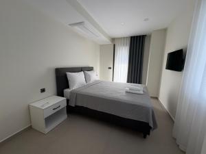 a small bedroom with a bed and a night stand at Villa Mare Luna & Villa Mariposa - Dream Luxury Summer Residences by the Aegean Sea in Marmaris +48 photos