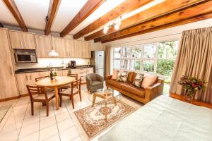 een keuken en woonkamer met een bank en een tafel bij Protea Garden Cottage in Stellenbosch