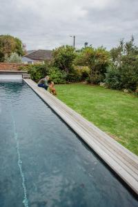 een man en een kind naast een zwembad bij Protea Garden Cottage in Stellenbosch +17 foto's