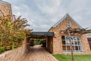 een ingang van een bakstenen gebouw met een luifel bij Protea Garden Cottage in Stellenbosch