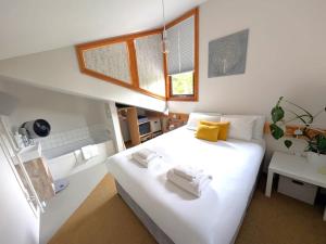 a bedroom with a large white bed with yellow pillows at Unique & Rural Child Friendly Annexe with Large Gardens, Games & Tennis Court - Chichester Holiday Properties in Chichester
