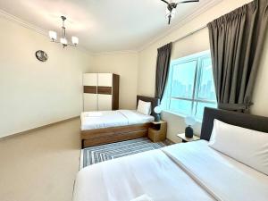 a hotel room with two beds and a window at Waterfront Modern loft overlooking downtown 3BR in Sharjah