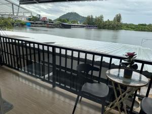 a table and chair on a balcony next to a river at Riverside Hostel Phuket in Phuket +28 photos