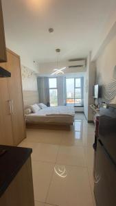 スラバヤにあるApartemen Anderson 09 Pakuwon mall Luxury Studio Apartment Connecting Mall, Pool & City Viewの大きなベッドルーム(ベッド1台、大きな窓付)