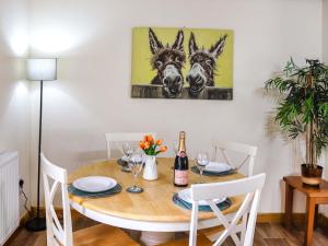 a dining room with a table with two donkeys painting on the wall at Cothi Cottage - Uk49588 in Llansawel
