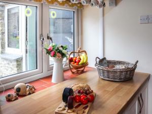 a kitchen with a counter with a basket of fruits and vegetables at Cothi Cottage - Uk49588 in Llansawel