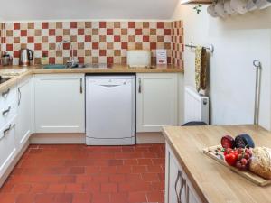a kitchen with white cabinets and a dishwasher at Cothi Cottage - Uk49588 in Llansawel
