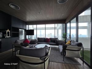 a living room with a couch and a table and chairs at The Luxe Infinitum By Elite Home KLCC in Kuala Lumpur