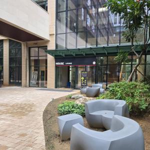 un edificio con panchine bianche di fronte a un edificio di 원스테이 가산디지털단지 a Seul