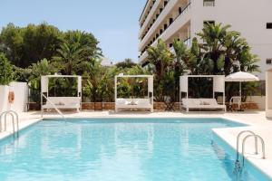 a swimming pool with two chairs and a hotel at Hotel Moon Dreams Paraiso - Adults Recommended in Es Cana