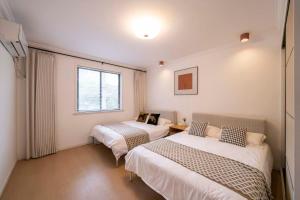 a room with two beds and a window at Book and Bed-People's Square in Shanghai