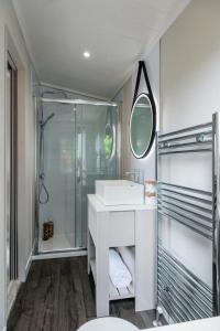 a white bathroom with a sink and a shower at Sunniva Lodge in Malton