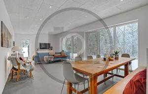 Una sala de estar con una mesa y sillas de madera. en 4 Bedroom Awesome Home In Thyholm, en Oddesund Syd