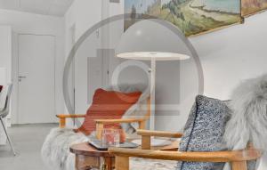 Una sala de estar con una silla y un espejo. en 4 Bedroom Awesome Home In Thyholm, en Oddesund Syd