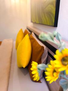a bunch of pillows sitting on a bed with flowers at Life in Phrom Phong in Khlong Toei