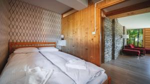 Un dormitorio con una cama y una silla roja. en Mocarni, Sun & Snow, en Kościelisko