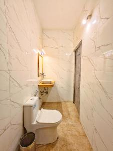 a small bathroom with a toilet and a sink at Thar Tribe Hostel Jaisalmer in Jaisalmer