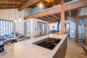 an open kitchen with wooden ceilings and a large island at More Mountain - La Ferme De Morzna In Morzine in Morzine