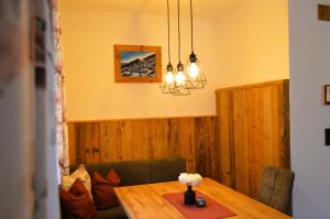 a dining room with a wooden table with flowers on it at Ferienwohnung Rohrmoser mit 2 Schlafzimmern in Hüttschlag