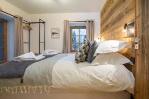 a bedroom with a large bed with pillows at More Mountain - La Ferme De Morzna In Morzine in Morzine