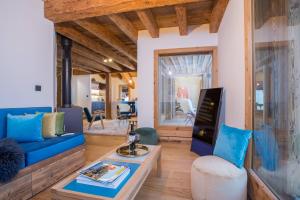 a living room with a blue couch and a tv at More Mountain - La Ferme De Morzna In Morzine in Morzine