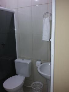 a small bathroom with a toilet and a sink at Pousada Ancoradouro in Cananéia +33 photos