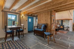 a living room with a table and chairs and a fireplace at Nyth Fach Nanternis in Llandyssiliogogo