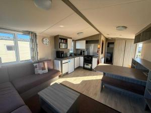 a living room with a couch and a kitchen at Salty Breezes in Ingoldmells