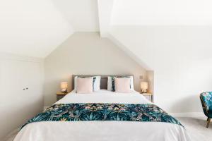 a bedroom with a large white bed with a floral bedspread at Pass the Keys Modern family home Garden Parking in Bourton on the Water