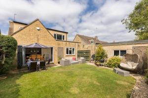 a backyard of a house with a table and chairs at Pass the Keys Modern family home Garden Parking in Bourton on the Water