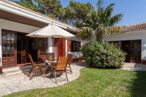 a patio with a table and chairs and an umbrella at Charming House and Terrace By Gt House in Colares